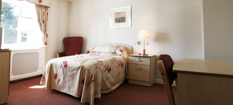 Bedroom with floral sheets in Sunnyside Care home